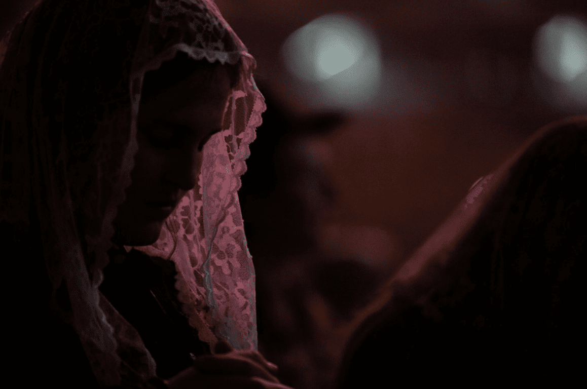 A woman prays before entering the sacrament of Confession. 